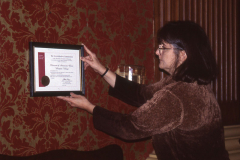 2000 Museum of American Glass Curator Emeritus, Gay Taylor, hanging the American Alliance of Museums Accreditation Certificate.