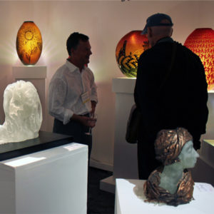 2 visitors observing the gallery exhibition booth during glass weekend