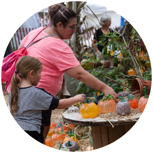 Mom and daughter picking out glass pumpkins at the Festival of Fine Craft