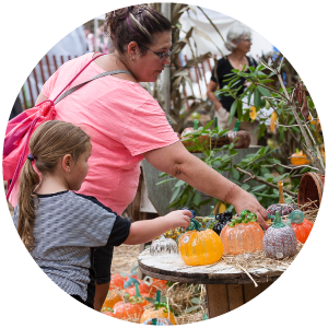 Mom and daughter picking out glass pumpkins at the Festival of Fine Craft