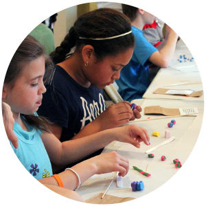 Circle crop of class of children creating clay beads