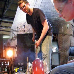 Artist part of the fellowship program working on glass piece in the glass studio