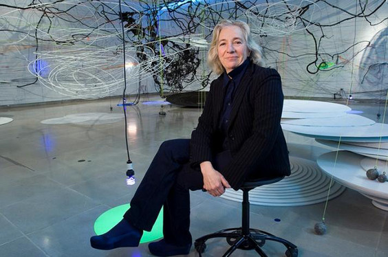 Judy Pfaff sitting on an armless chair