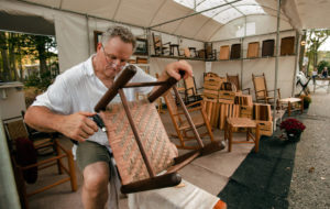 Artist working on wooden chair seat