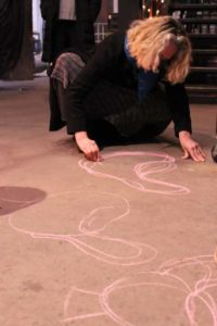 Paula Hayes Sketching artwork on the floor