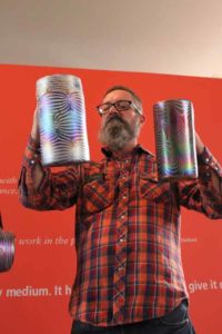 Virgil Marti holding two glass cylinders