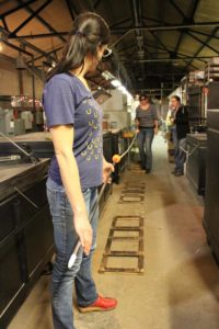 Erica Rosenfield holding glassblowing pipe