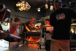 Artists working together on hot glass piece