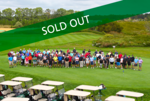 Sold Out banner for the WheatonArts Golf Classic, background with participants posing on the verdant green golf course