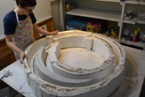 Fellow Karen Donnellan working on a large circular mold