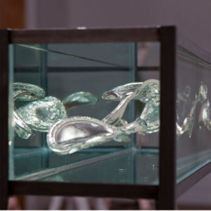 Jes Fan glass sculpture inside a display box