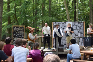 Armchair Wizards on an outdoor stage, performing for a crowd.