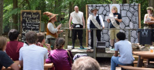 Armchair Wizards on an outdoor stage, performing for a crowd.