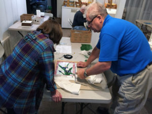 Two People Observe Stained Glass Piece