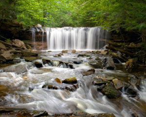 Photograph taken by James Evangelista of a waterfall, the white water flowing rapidly over and in between large rocks.