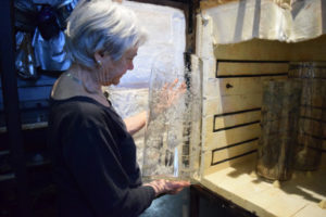 Artist Emily Brown reviewing glass cylinder