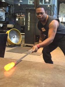 A student confidently shapes glass during the Glass Blowing Intensive: Next Steps class at WheatonArts