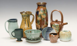 Assorted pieces by WheatonArts Ceramic Artists. Pitcher, teapot, cup, egg separator, sugar bowl, two vases and two bowls.