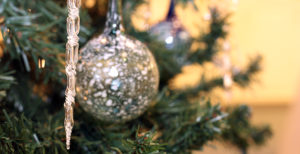 Closeup of glass icicle and ornaments hanging from tree