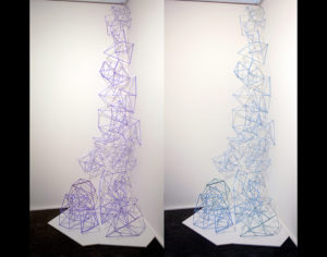 Glass cane sculpted into three dimensional, geometric shapes cascading from ceiling to floor. Created by Evan Voelbel.