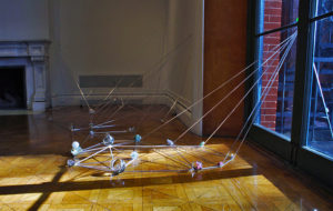 Rods go diagonally from window to floor, connecting at various points where there is a glass sphere. Created by Evan Voelbel