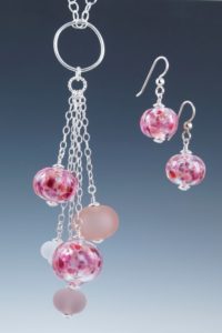 Necklace with pink, purple, and gray glass charms on a large link. Pink glass charm earrings. Created by Elizabeth Mitchell.