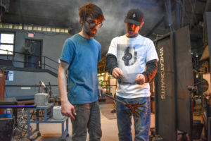 "Emanation 2019" Artist Tristin Lowe discussing plans with WheatonArts Glass Artist Brian R. in the WheatonArts Glass Studio.