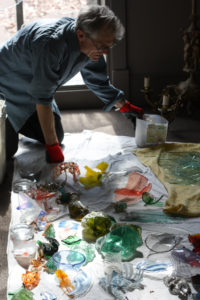 Richard Torchia cleaning the broken pieces of glass that will go into a drum of the Kaleidoscope.