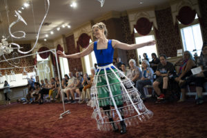 Emanation 2019 "Phantom Frequencies" 6-2-19 performance by Martha McDonald and Laura Baird, captured by Ryan Collerd. Martha dancing in a glass jingle skirt in the Museum lobby with a crowd behind her.