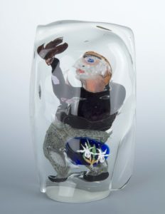 Figure of an abstract man and flowers encased in glass.