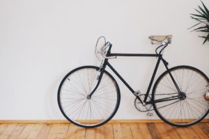 black bicycle parked indoors on wooden floor