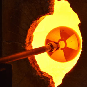 One of artist Jo Yarrington's uranium glass orbs is put into the gloryhole at the WheatonArts Glass Studio