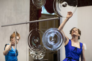 Martha McDonald and Laura Baird carefully touch the rondels for "Phantom Frequencies" at the Museum of American Glass