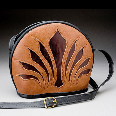 A leather bag with a blooming dark brown design and a black strap. Created by Frank Westfall.