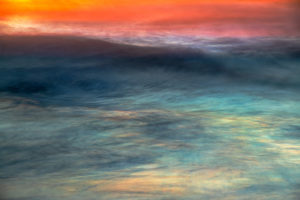 Photograph taken by Frederick Ballet of a rich seascape with both light and deep blues with a orange and pink sunset reflecting on the water