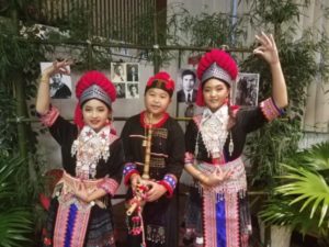 Three Hmong Dancers pose in front of bamboo.