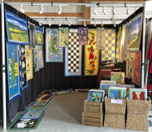 A booth showcasing the floor cloths of Ellie Wyeth.