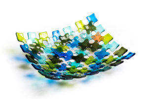 Blue, orange, green, teal, and white bowl by Stephanie Baness formed with small overlapping glass squares of each color