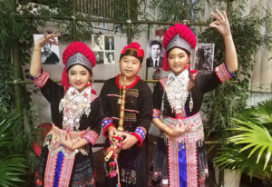 Three Hmong Dancers pose in front of bamboo.