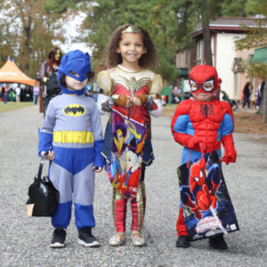 Three trick or treaters at HalloWheaton, left is dressed as Batman, center is Wonder Woman, and the right child is dressed as Spider-Man