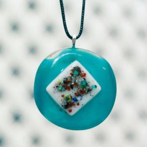 Sky blue glass fused pendant with a white square in the middle sprinkled with colorful pieces of glass frit.