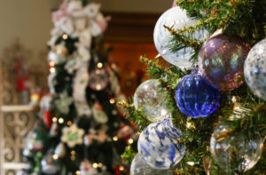 Closeup of trees decorated for the holidays in the Museum Stores. Each tree is decorated with blown glass ornaments.