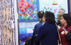 Visitors admiring quilts hung in the Event Center.