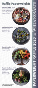 Four paperweights to be won at the Paperweight Raffle 2020 at WheatonArts. From top to bottom, the top paperweight by Gordon Smith has succulent plants and a red dragonfly on dirt with pebbles. The second paperweight by Cathy Richardson has a yellow-green butterfly flock. The third paperweight by David Graeber has a cocktail tree with all different fruits. The final paperweight by Paul J. Stankard has raspberries wrapped around a honeycomb.