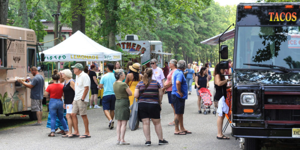 A crowd of people at WheatonArts engaging with food vendors and food trucks.