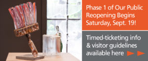 Two text boxes. Phase 1 Reopening Begins Saturday, September 19! (top). Gray box underneath states Timed ticketing info and visitor guidelines available here. Two bright orange arrows point to right. Image on left shows a large glass paintbrush with pink and red bristles.