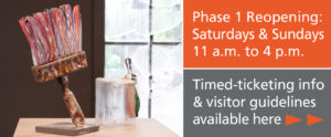 Two text boxes. Phase 1 Reopening: Saturdays and Sundays 11 a.m. to 4 p.m. (top). Gray box underneath states Timed ticketing info and visitor guidelines available here. Two bright orange arrows point to right. Image on left shows a large glass paintbrush with pink and red bristles.