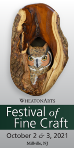 A vertical banner for the WheatonArts Festival of Fine Craft on October 2 & 3, 2021. An organic wooden oval that houses a small wooden owl, carved by Tom Ahern, sits on top of the text.