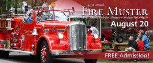 Image of the banner for Fire Muster. On the left side of the banner is a red antique fire truck being driven outside on the WheatonArts campus. A man and two kids sit close by at a brown circular picnic table watching the truck go by. A maroon shadow extends from the top right of the banner with white text over it that reads "42nd annual Fire Muster in partnership with the Glasstown Antique Fire Brigade August 20". At the bottom right is a rectangular maroon banner that reads "FREE Admission!".