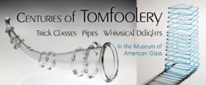 Image of a banner for the Centuries of Tomfoolery exhibit in the WheatonArts Museum of American Glass. At the top of the banner is black text that reads "Centuries of Tomfoolery". Underneath is more black text that reads "Trick Glasses", "Pipes", and "Whimsical Delights". On the left side of the banner is a large horizontally rectangular image of a clear horn-shaped trick glass in front of a white to gray gradient background. The background starts white at the bottom and turns darker towards the top of the image. The glass has six clear glass rings with small swirls in groups of two throughout the horn, a small knob at the tip, and a thick rim around the opening. On the right side of the banner is smaller vertically rectangular image of a glass Jacob's Ladder found in the WheatonArts Museum of American Glass. The tall piece is made up of a long continuous thin glass rod that spirals in square shapes from top to bottom. The piece is resting on a white background and it's shadow extends from the piece to the bottom left corner of the image. In between the two images. below the black text, is blue text that reads "In the Museum of American Glass".